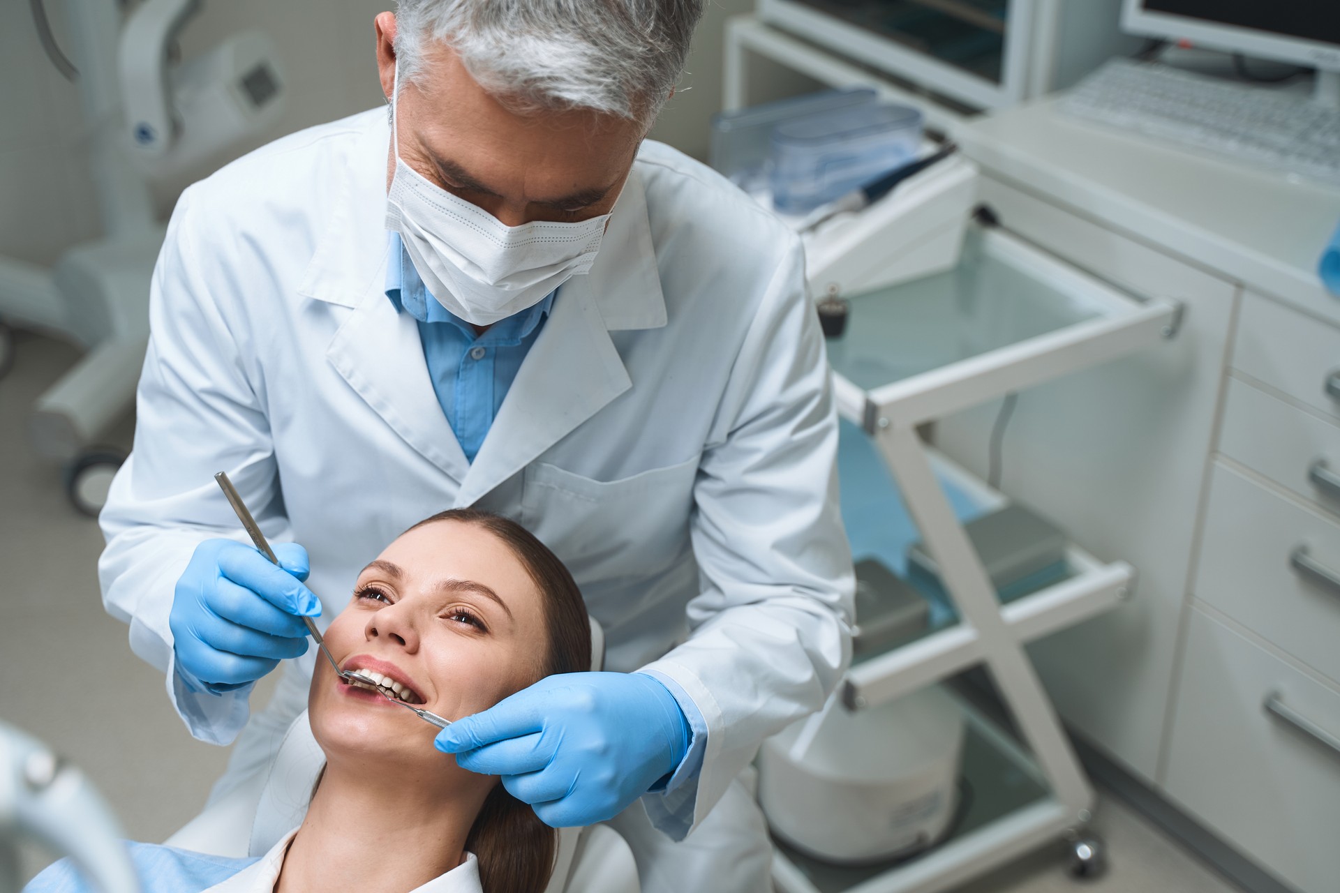 Male dentist is examining woman stock photo