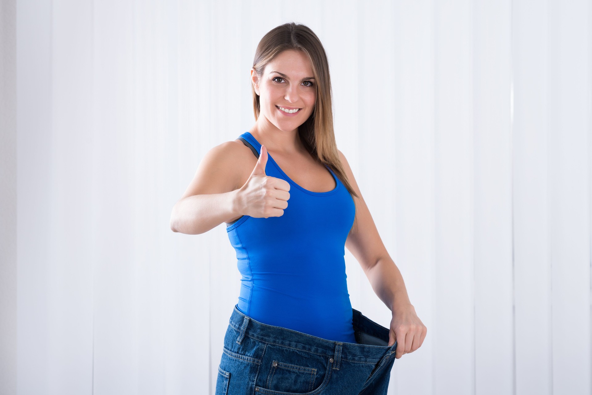 Woman Showing Her Weightloss By Wearing Jeans