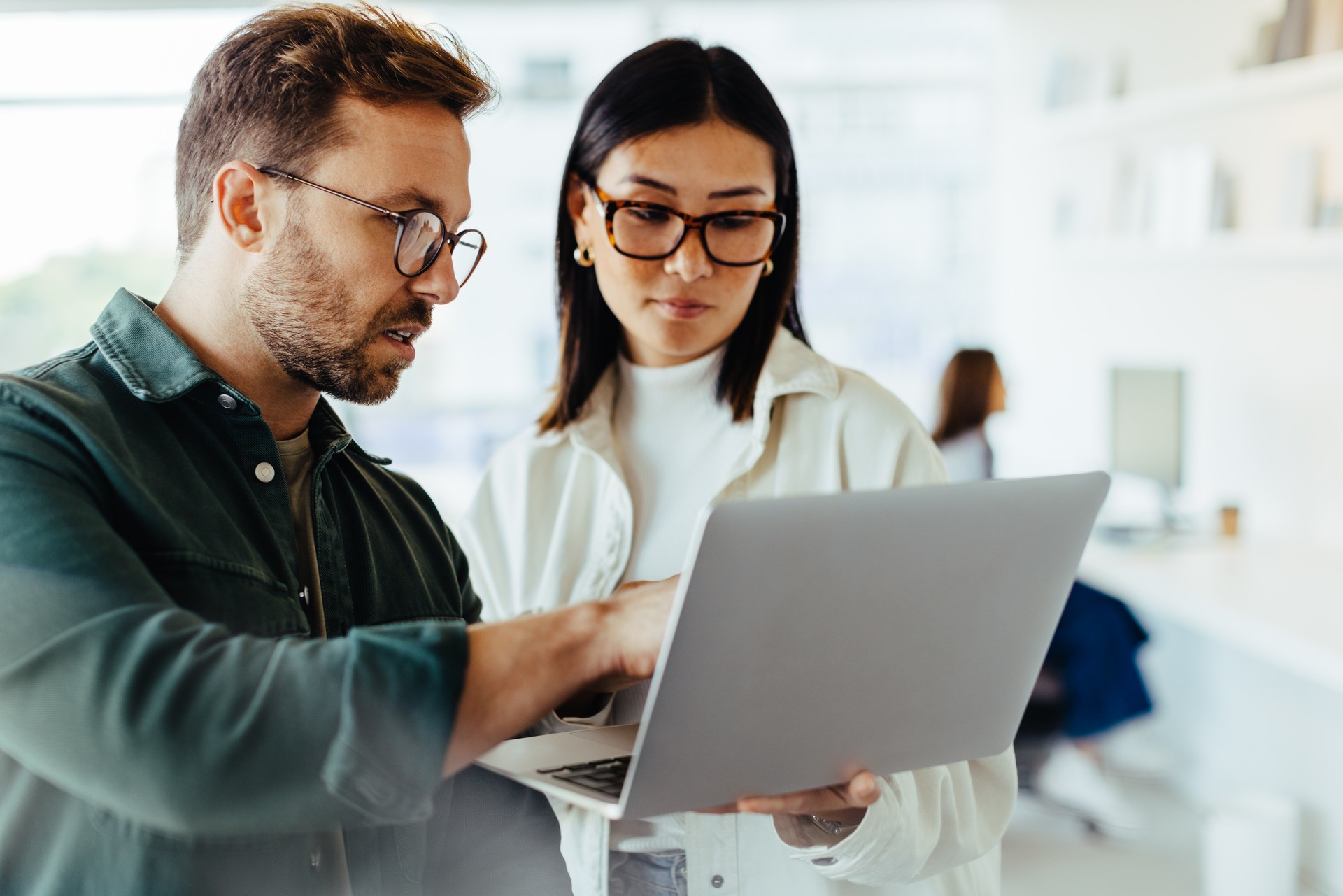 Design professionals using a laptop together in an office